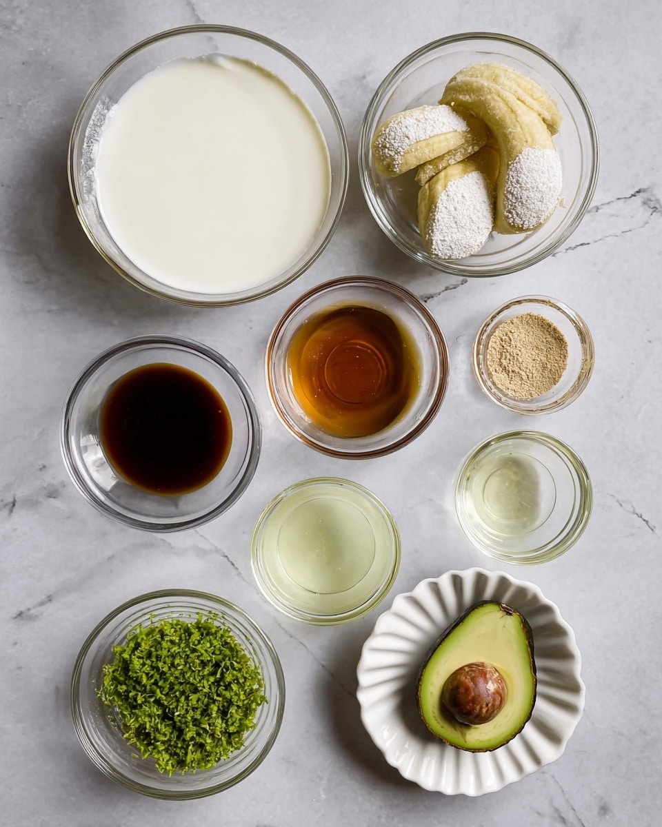 The image shows eight small clear glass bowls and one white fluted dish arranged neatly on a white marbled surface. The largest bowl contains a smooth, white creamy liquid. Another medium bowl holds three peeled pale yellow plantains dusted with white flour. A small bowl has dark amber liquid, while another small bowl contains a light brown powdery substance. One medium bowl has a translucent pale yellow liquid. There is a clear glass bowl with a dark, thin liquid. Half of an avocado with a large brown seed sits on the surface next to a white dish filled with bright green finely chopped herbs or zest. photo taken with an iphone --ar 4:5 --v 7
