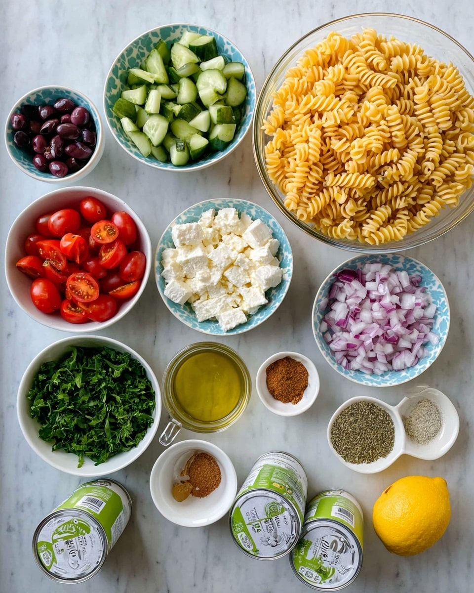 The image shows various ingredients laid out on a white marbled surface, ready for making a fresh salad. There is a large clear glass bowl filled with yellow rotini pasta at the top right. Around it are smaller white bowls and two small blue patterned bowls holding diced red onion, chopped parsley, sliced cucumber, cherry tomatoes halved, cubed white cheese, and sliced black olives. Two cans of chickpeas are placed side by side near the bottom right. A small glass measuring cup with golden olive oil sits near the center. There are also small white dishes containing minced garlic, mixed dried herbs, salt, and a brown spice. A halved lemon provides a bright yellow accent near the top right. Everything is neatly arranged for easy access. Photo taken with an iphone --ar 4:5 --v 7
