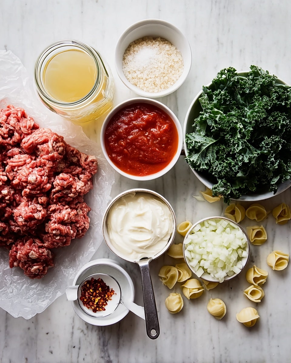 The image shows several cooking ingredients on a white marbled surface arranged neatly. There is a pile of raw ground meat on wax paper on the left side, next to a glass jar of broth with a yellowish color. Above the meat are two small white bowls, one filled with coarse salt-like grains and the other with bright red tomato sauce. To the right of the meat is a metal measuring spoon filled with white cream, placed in front of a small white plate with red chili flakes. Nearby, there is a clear glass bowl filled with chopped white onions. Scattered around the spoon and bowls are small pale yellow tortellini pasta pieces. On the far right, there is a white bowl filled with fresh dark green chopped kale leaves. Photo taken with an iphone --ar 4:5 --v 7
