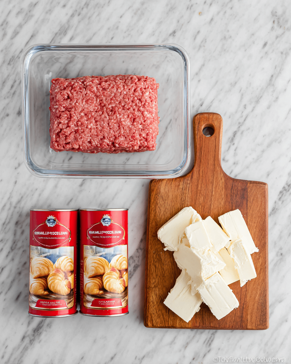 The image shows three main ingredients arranged on a white marbled surface: at the top is a clear rectangular glass container holding a single block of raw ground meat with a reddish-pink color and a slightly coarse texture. Below it on the left side are two red cylindrical cans of crescent rolls with images of golden-brown baked crescent shapes on the label. On the right side, there is a small wooden cutting board with a handle, holding several thick pieces of cream cheese that are white and creamy in texture, some stacked loosely on top of each other. Photo taken with an iphone --ar 4:5 --v 7