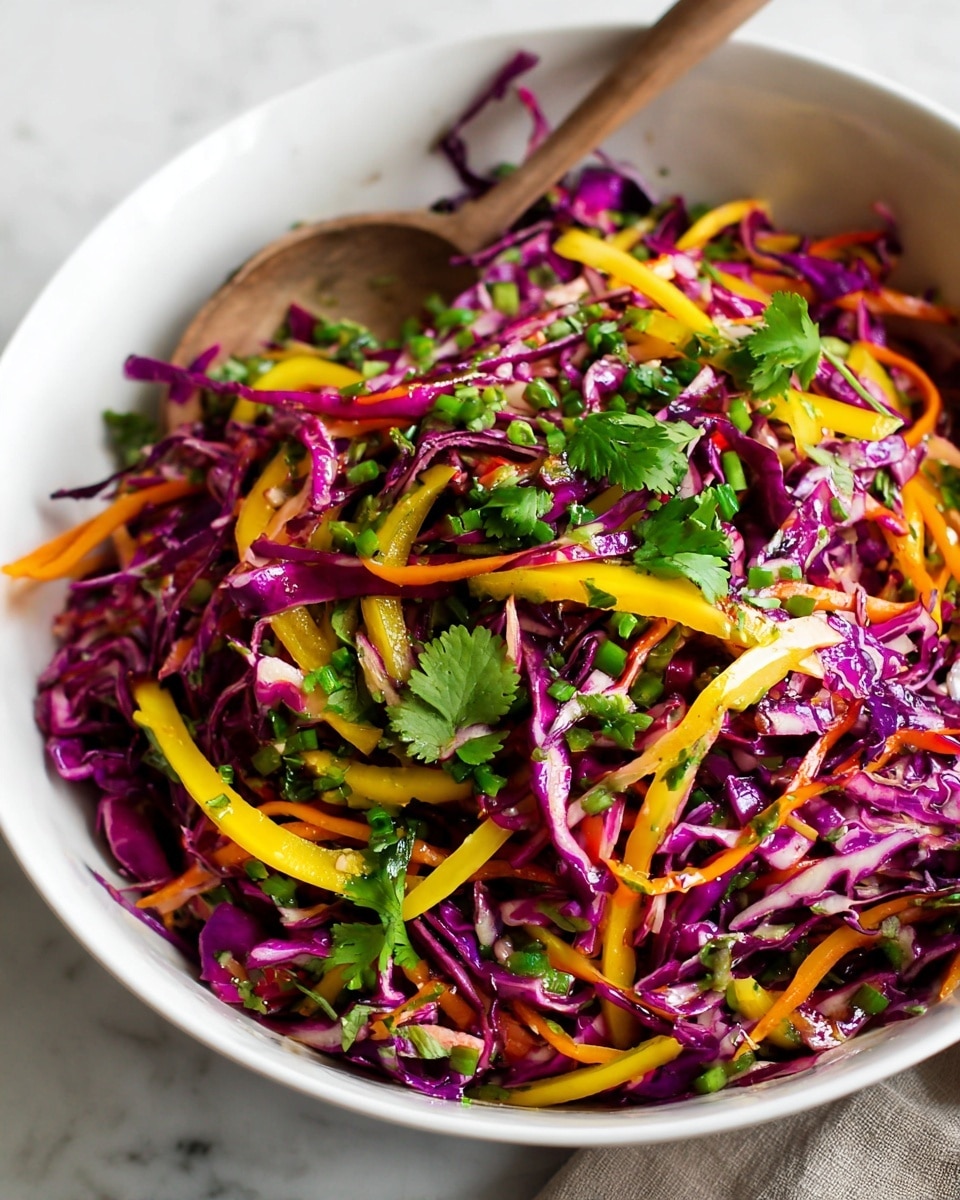 A white bowl filled with a colorful layered salad, showing shredded purple cabbage as the top layer with thin strips of yellow and orange bell peppers mixed in. Bright green chopped scallions and cilantro leaves are scattered over the whole salad, giving it freshness. The textures are crisp and varied, with the cabbage having a curly look and the peppers smooth and shiny. A wooden spoon rests inside the bowl, partially visible. The background features a white marbled surface. Photo taken with an iphone --ar 4:5 --v 7